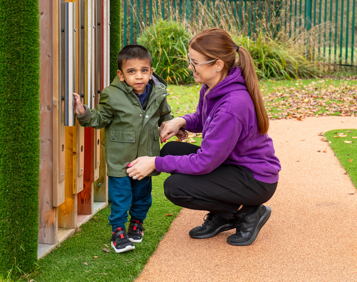 staff member playing with child in the garden